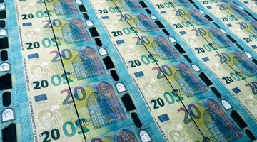 Une série de billets de 20 euros empilés, avec en arrière-plan un design d'un bâtiment.