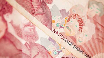 Gros plan de billets de banque belges mettant en avant le texte BANQUE NATIONALE DE et différents visages dans un style artistique.