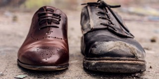 Comparaison d'une nouvelle chaussure en cuir brun brillant avec une chaussure noire usée et sale.