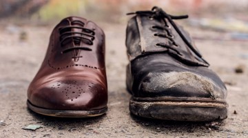 Comparaison d'une nouvelle chaussure en cuir brun brillant avec une chaussure noire usée et sale.