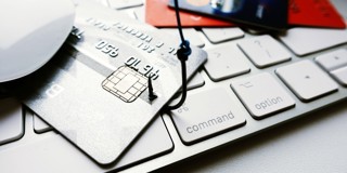 Creditcards en een muis liggen op een laptoptoetsenbord, wat wijst op online winkelen of betalingen.