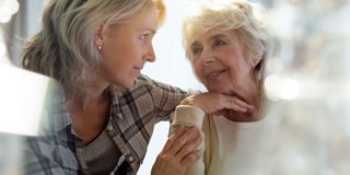 Une jeune femme écoute attentivement une femme plus âgée pendant qu'elles ont une conversation ensemble.