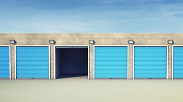 Opvallende blauwe garagedeuren, met de derde deur van links geopend.
