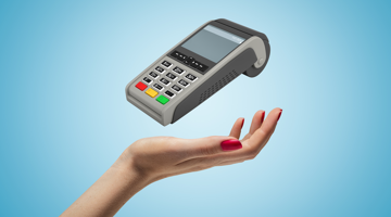 Een hand houdt een pinapparaat voor een blauwe achtergrond, klaar voor gebruik.