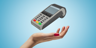 Une main tenant un terminal de paiement flottant, avec des boutons clairement visibles et un écran.