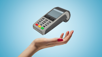 Une main tenant un terminal de paiement flottant, avec des boutons clairement visibles et un écran.