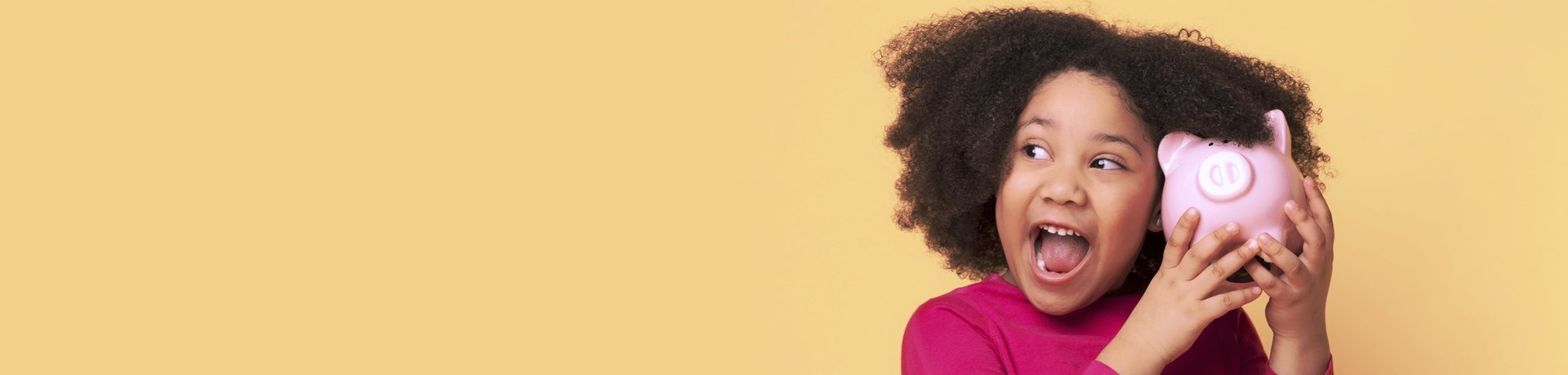Meisje met donker, krullend haar houdt een roze spaarpot vast, tegen een gele achtergrond.