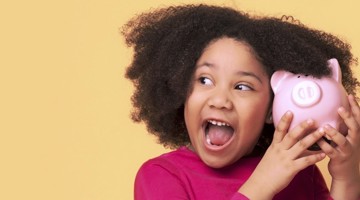 Meisje met donker, krullend haar houdt een roze spaarpot vast, tegen een gele achtergrond.