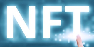 Een vinger wijst naar de grote oplichtende letters NFT op een blauwe achtergrond, wat digitale kunst of activa symboliseert.