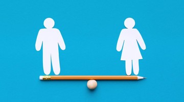 Icônes d'un homme et d'une femme maintenus en équilibre par un crayon, symbolisant l'égalité entre les sexes.