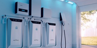 Drie witte energieopslagsystemen met een zonnepaneelomvormer aan de muur, verlicht door blauwe lampen.