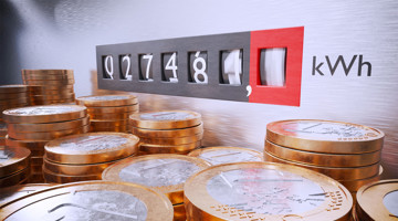 Digitale energiemeter met een stand van 27.481 kWh, voor een stapel gouden munten.
