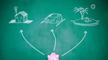 Un cochon tirelire rose se trouve sous un tableau noir avec trois flèches pointant vers une maison, une voiture et une plage, symbolisant des options d'épargne.
