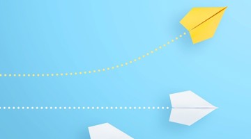 Un avion en papier jaune et blanc s'envole vers le haut sur un fond bleu, avec une ligne pointillée indiquant sa trajectoire.