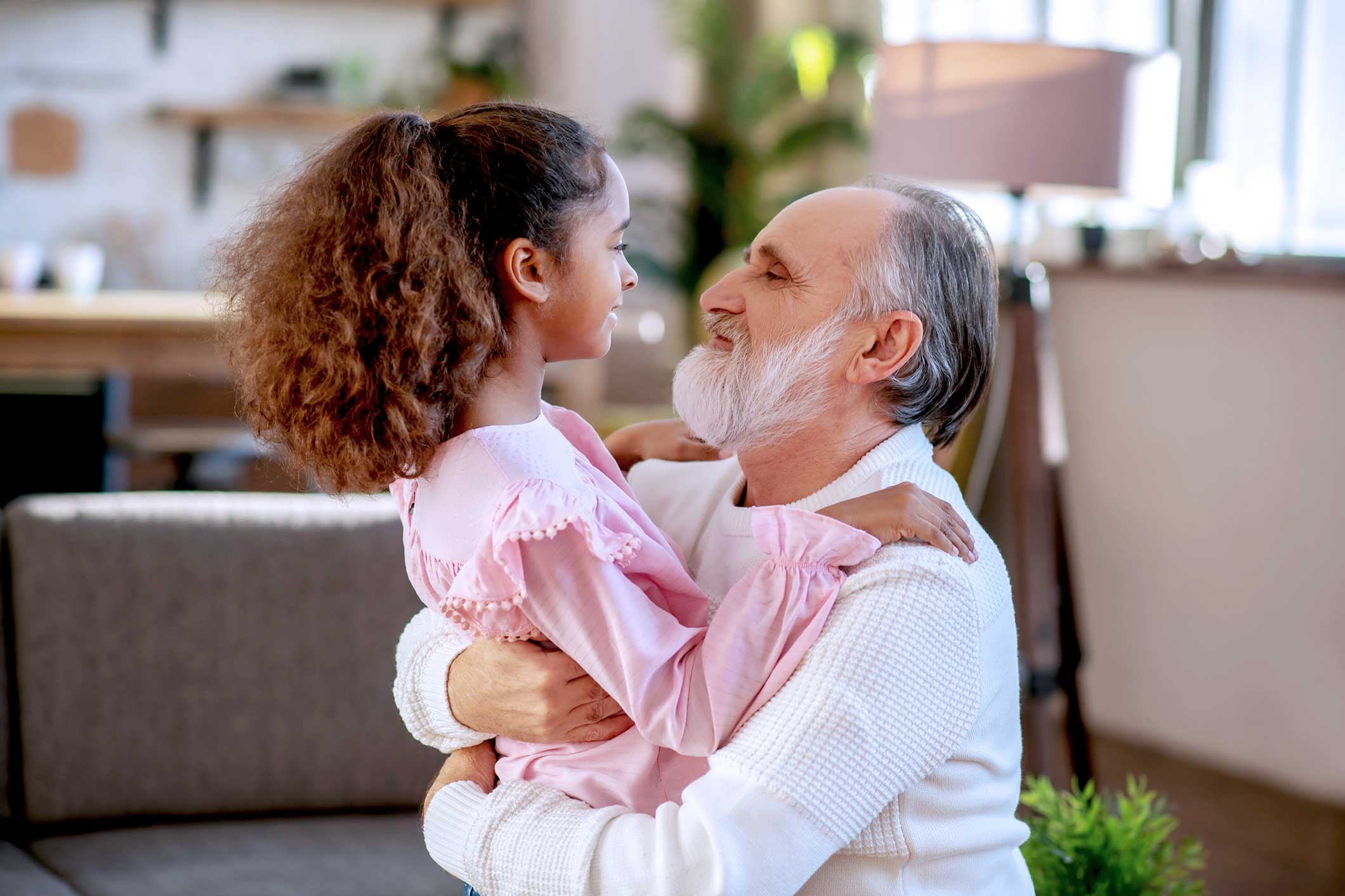 Un parent jouant avec un enfant, tous deux souriants dans un environnement chaleureux et familier.